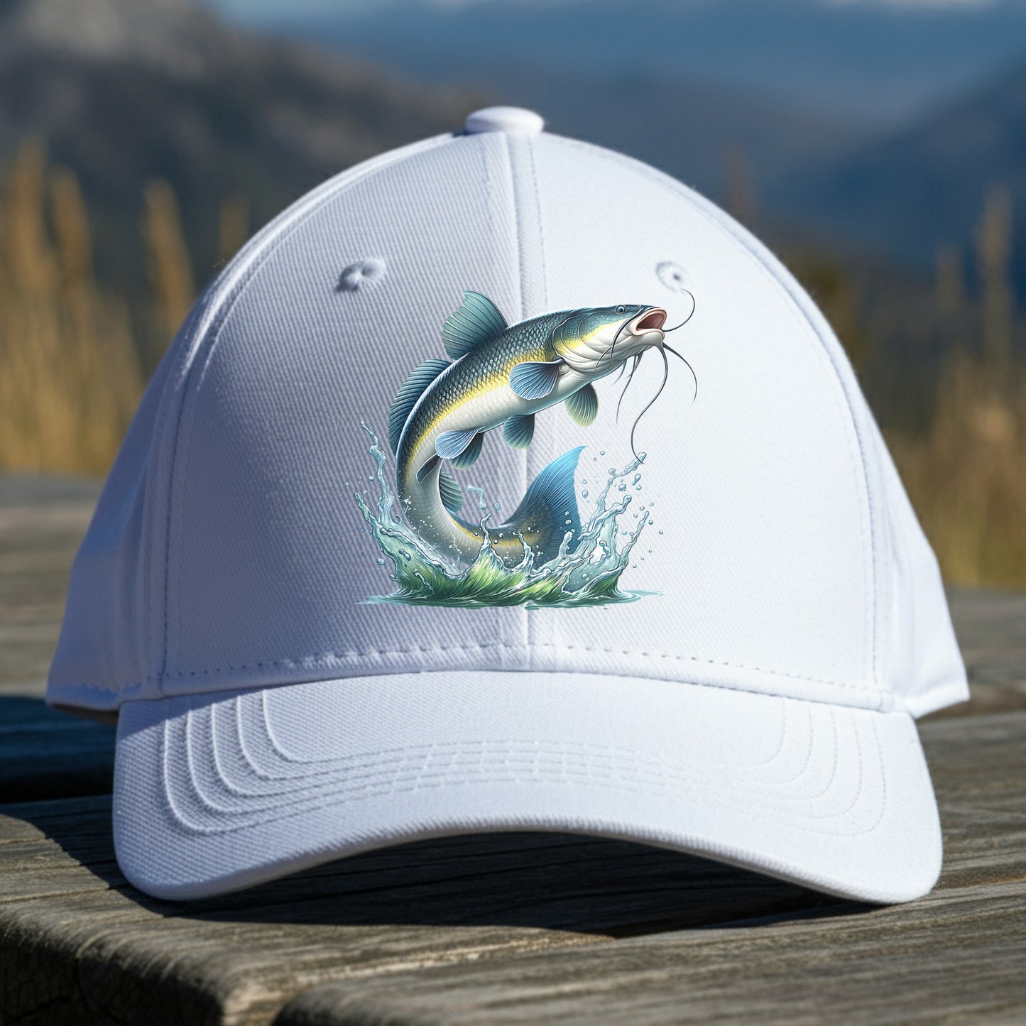 White cap with a catfish design on a wooden surface with a mountainous background