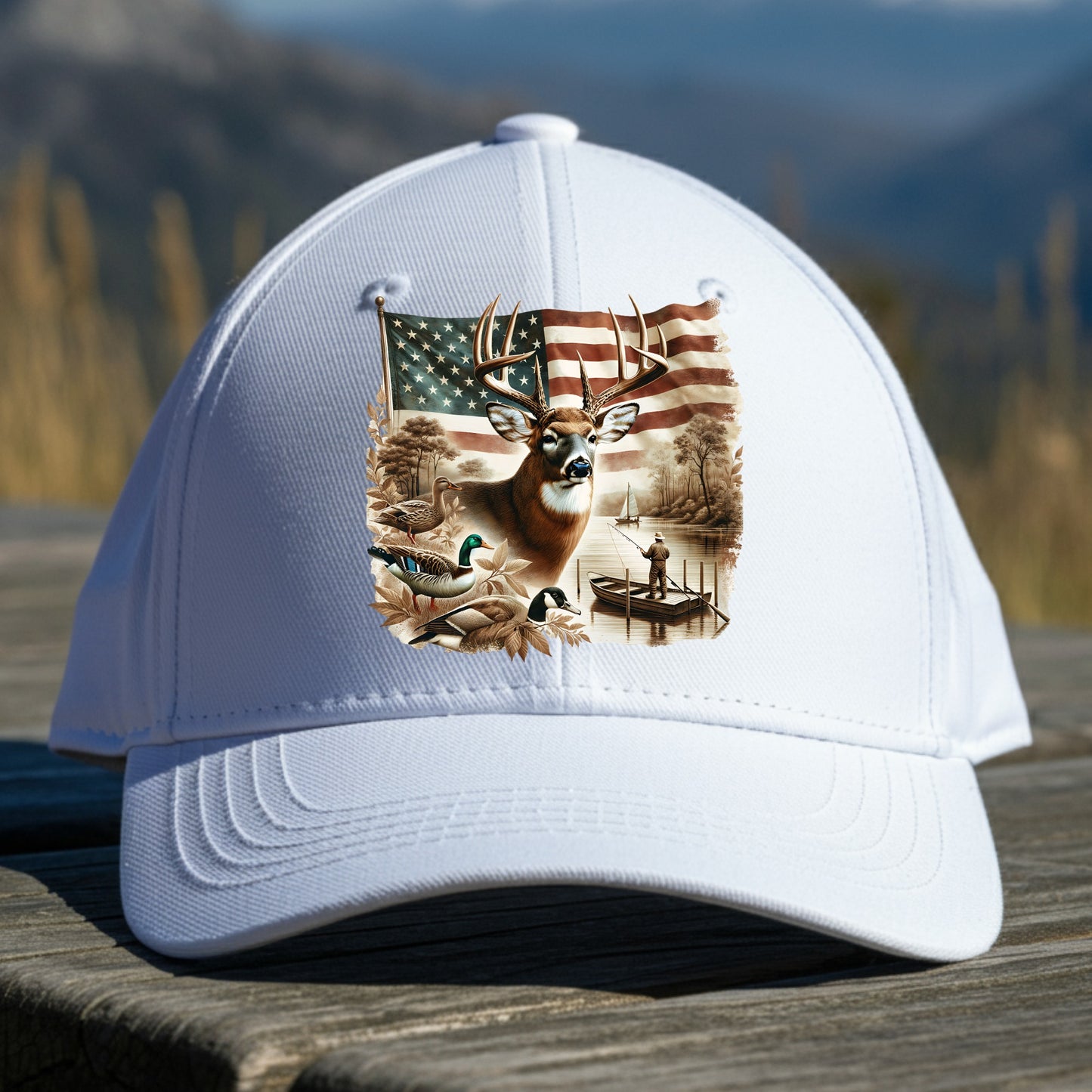White cap with a deer and American flag design on a wooden surface with a mountain background