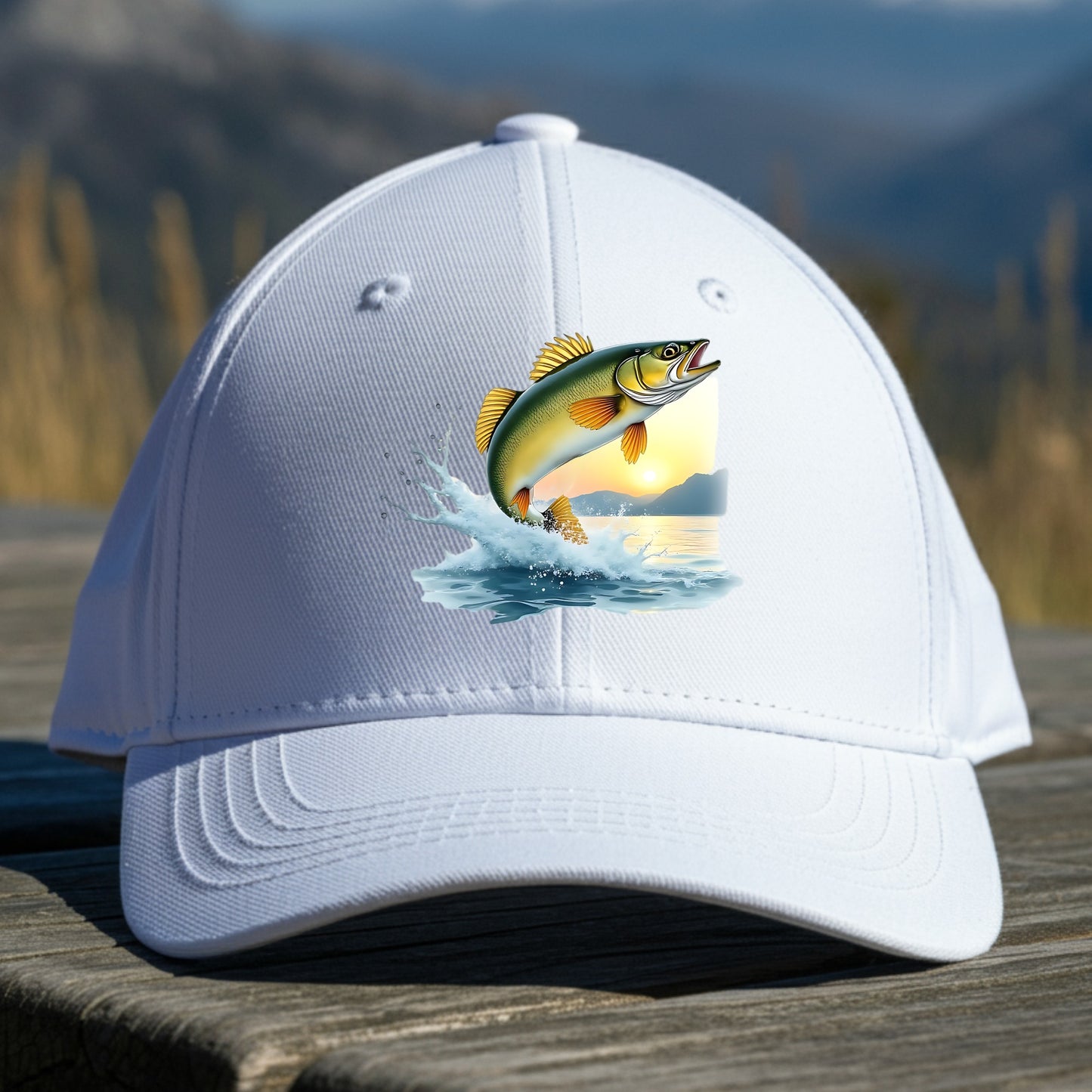 White cap with a walleye fish design on a wooden surface with a mountain background