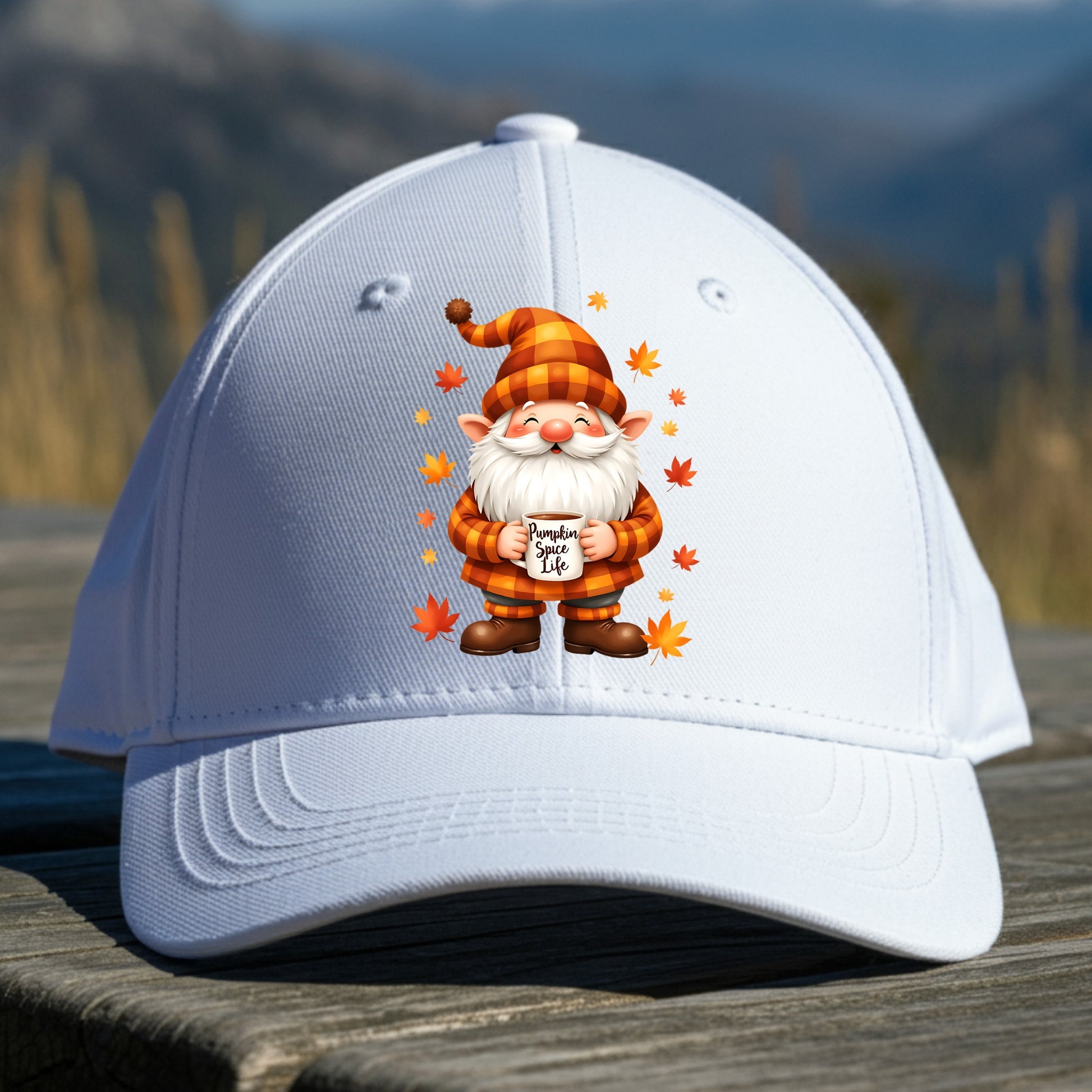 White cap with a cartoon gnome holding a pumpkin spice latte cup on a wooden surface with a mountain background.