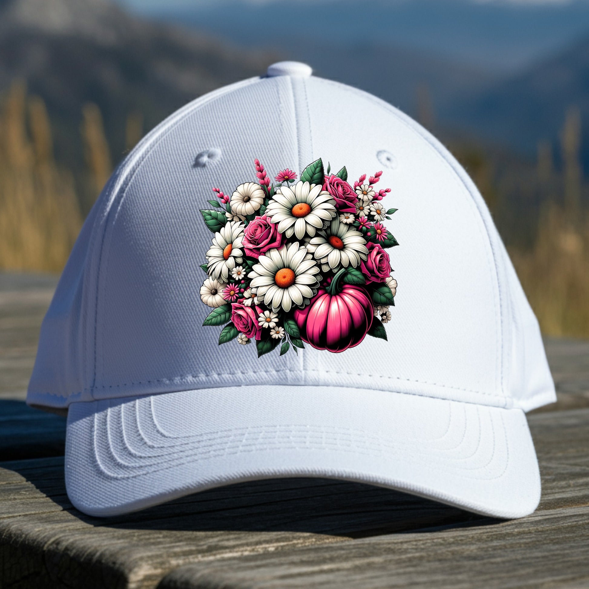 White cap with floral design on a wooden surface with a mountainous background