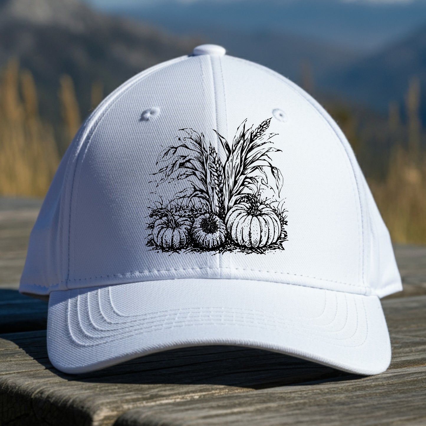White cap with black pumpkin design on a wooden surface with a mountain background