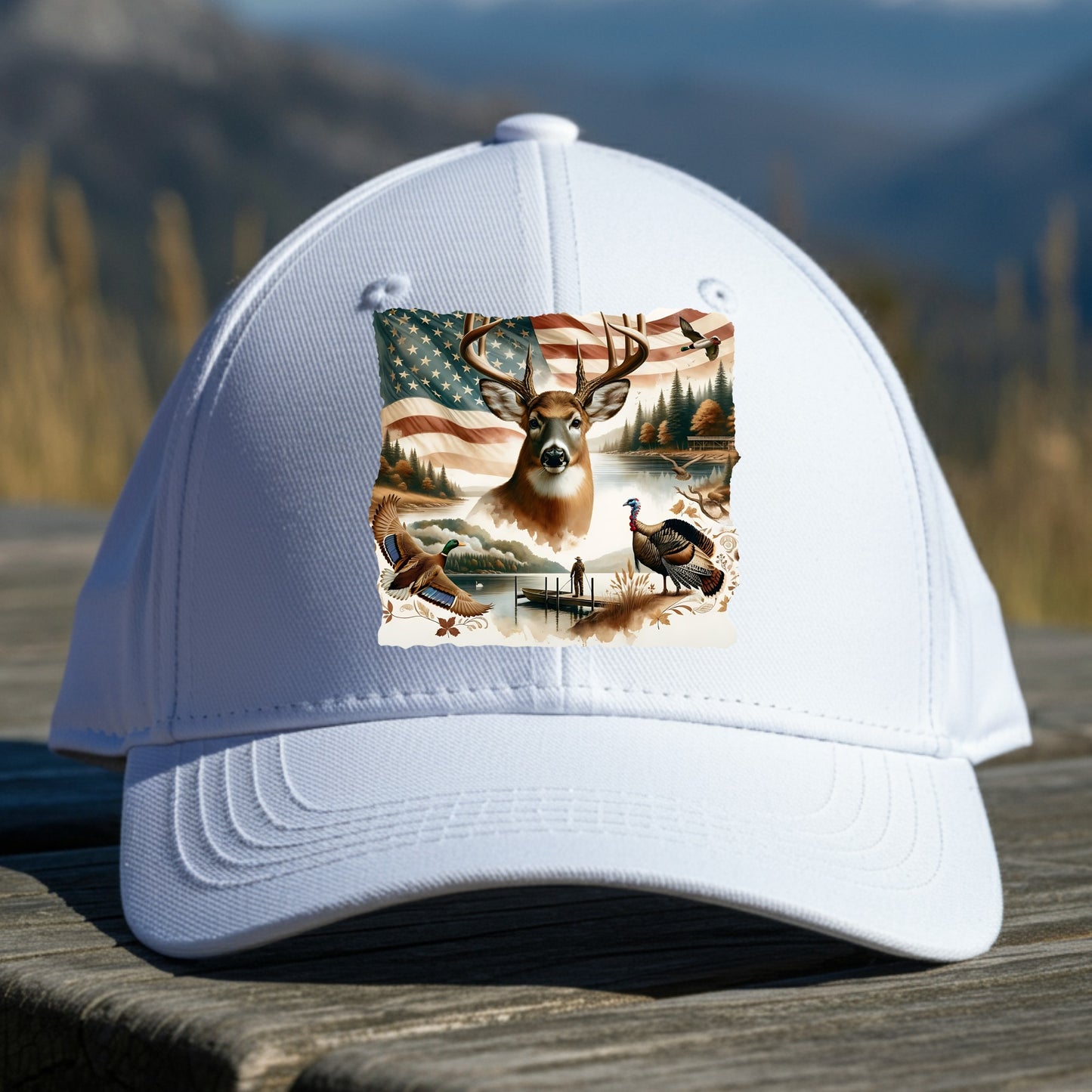 White cap with a nature-themed design featuring a deer, American flag, and turkey on a wooden surface with a mountain background.