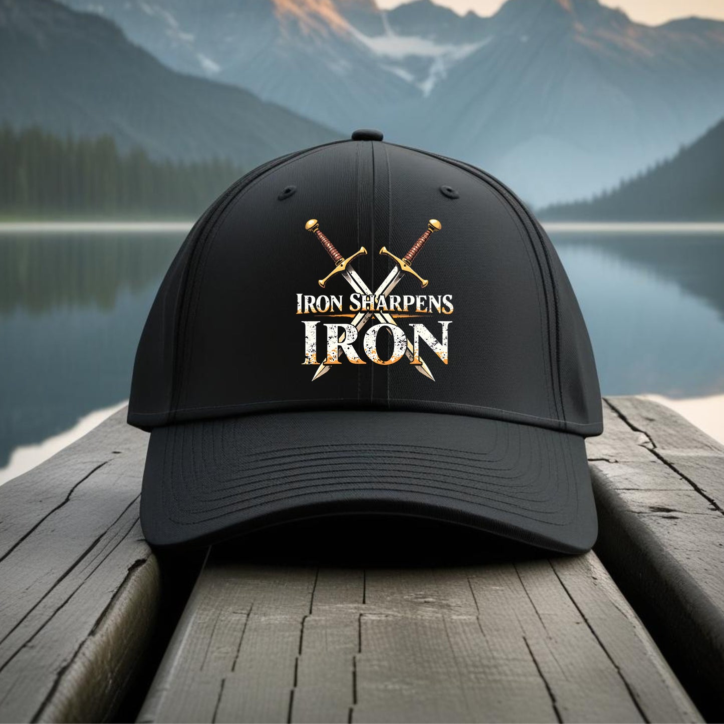 Black cap with 'Iron Sharpens Iron' logo on a wooden dock with a mountain and lake background