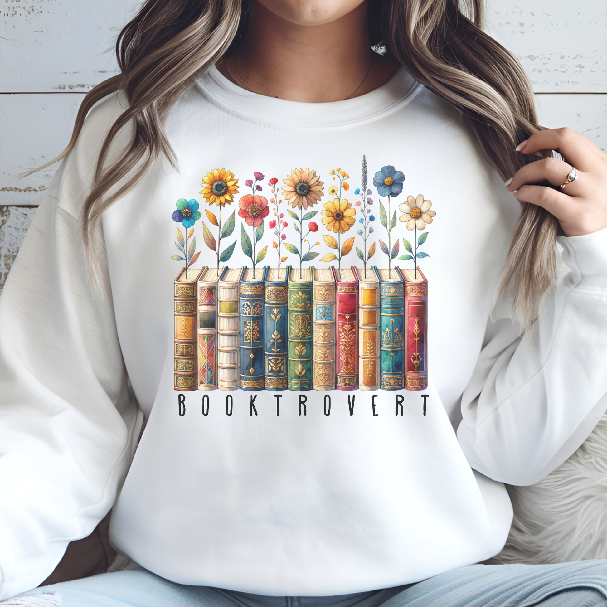 Booktrovert Book Lover PNG Digital Design on a woman's white sweatshirt
