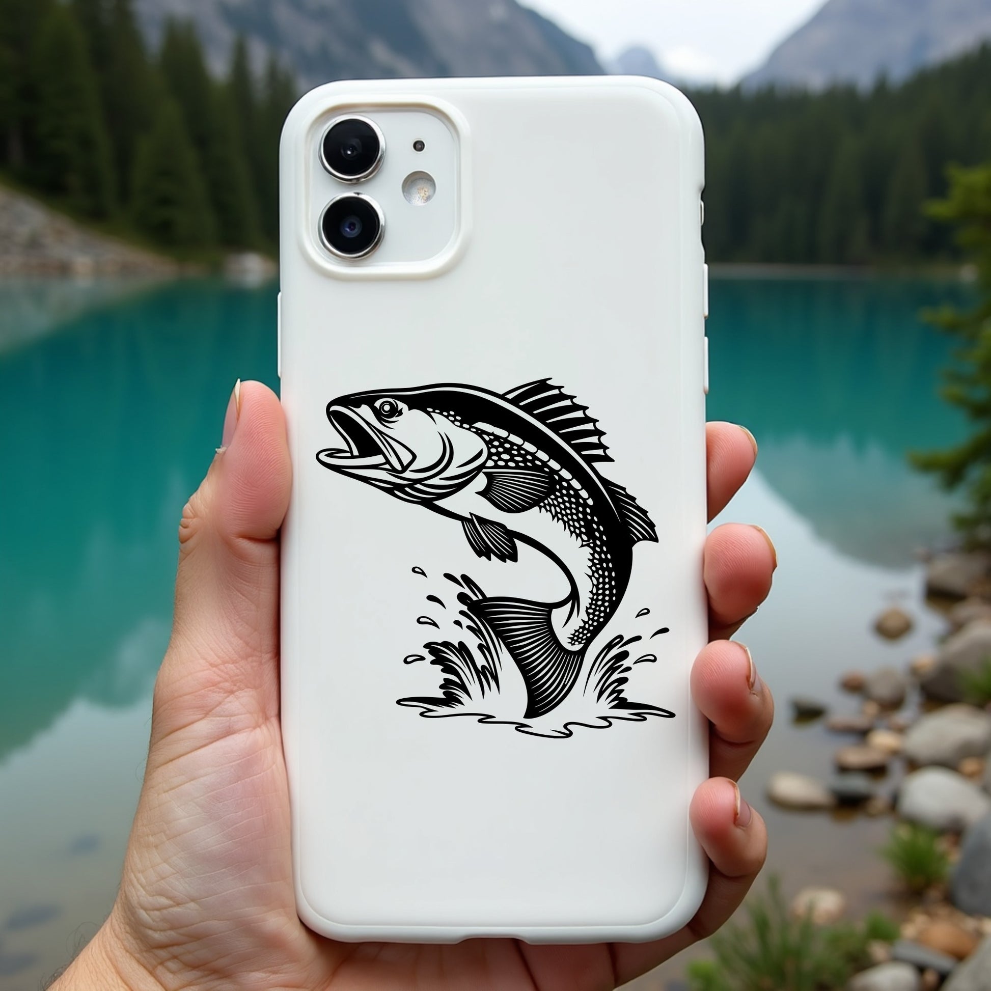 Phone case with walleye fish design held in front of a scenic lake and mountains