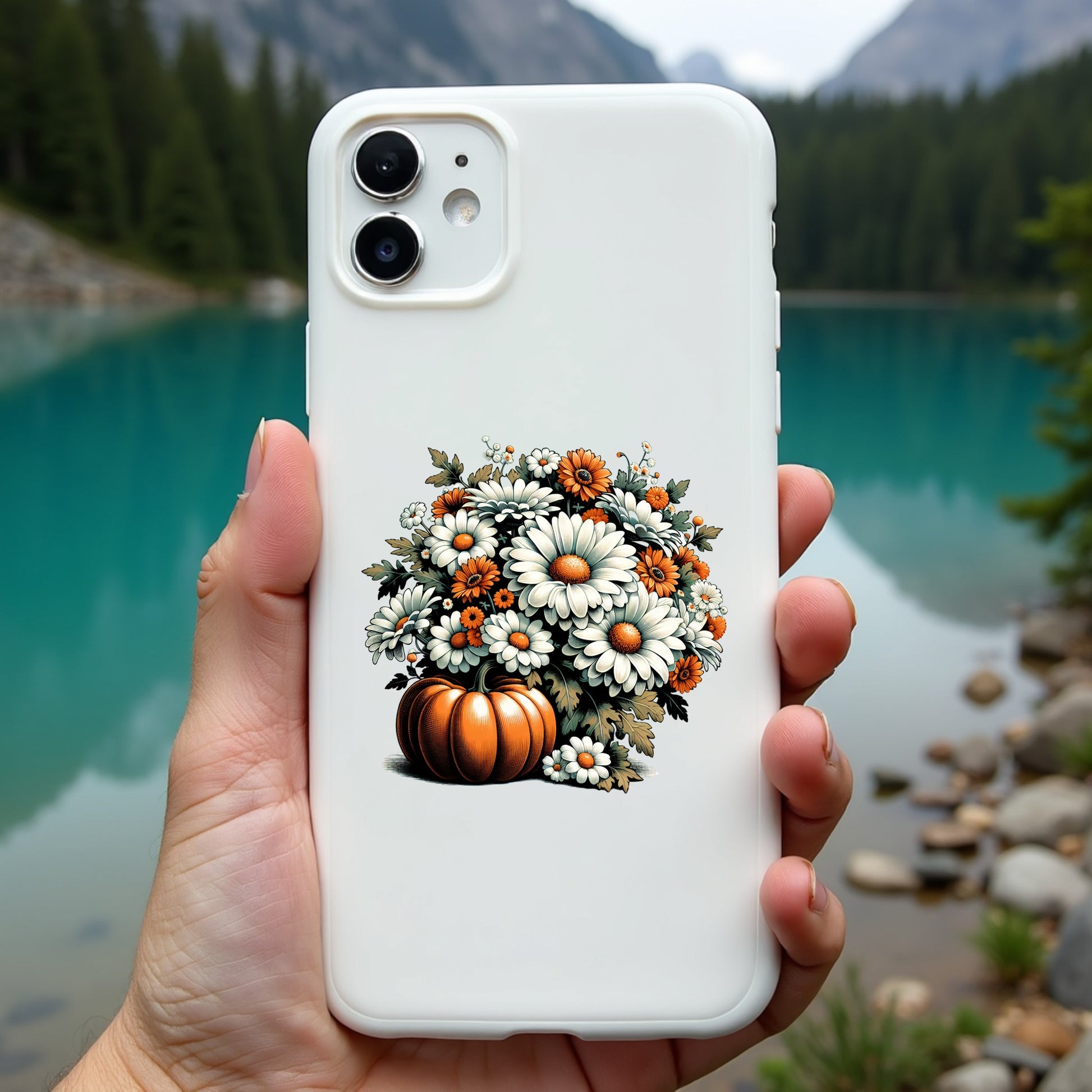 Phone case with floral design held in front of a scenic lake and mountains