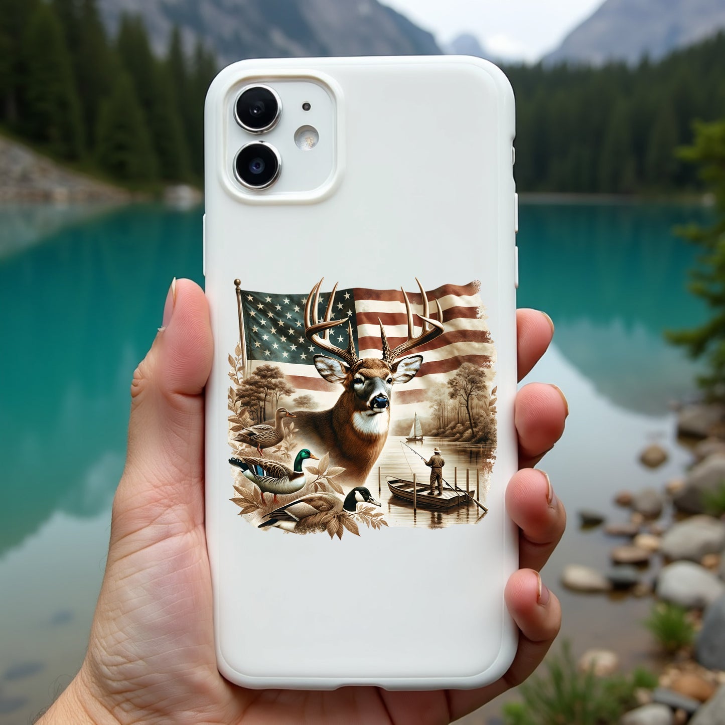 Phone case with nature-themed design held in front of a scenic lake and mountains.