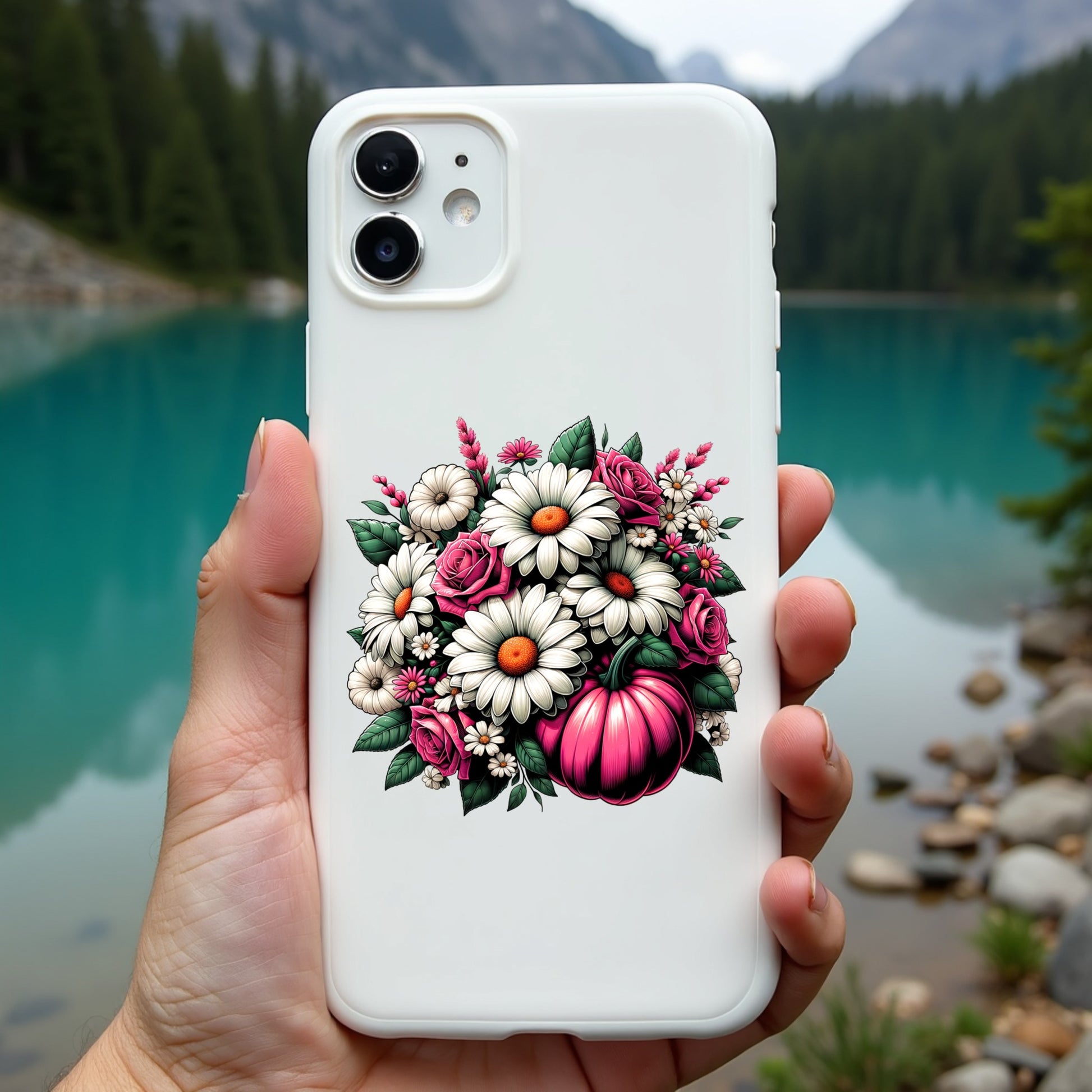 Phone case with floral design held in front of a scenic lake and mountains