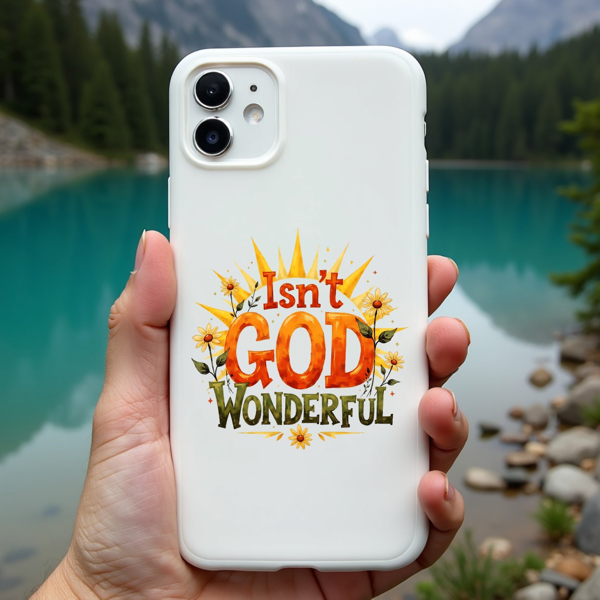 Phone case with 'Isn't God Wonderful' text held in front of a scenic lake and mountains.
