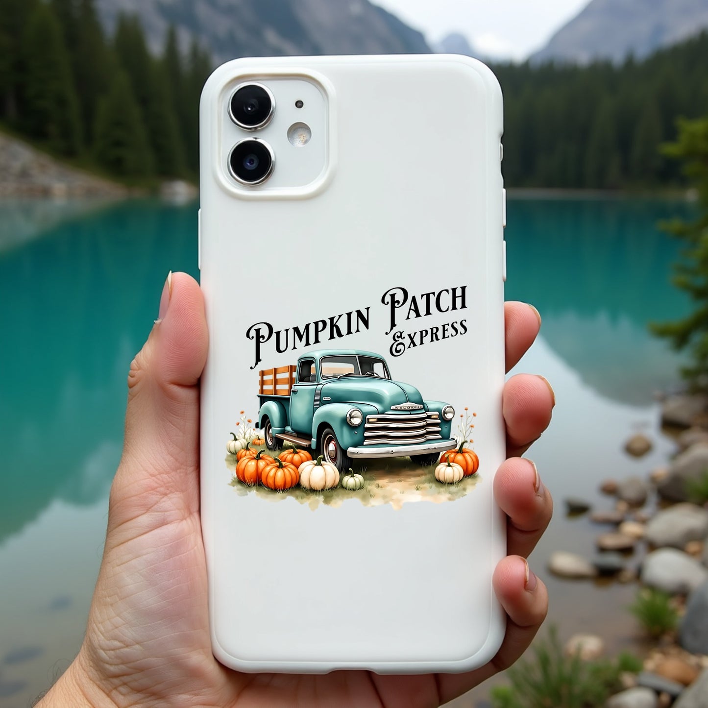 Phone case with pumpkin patch design held in front of a scenic lake and mountains
