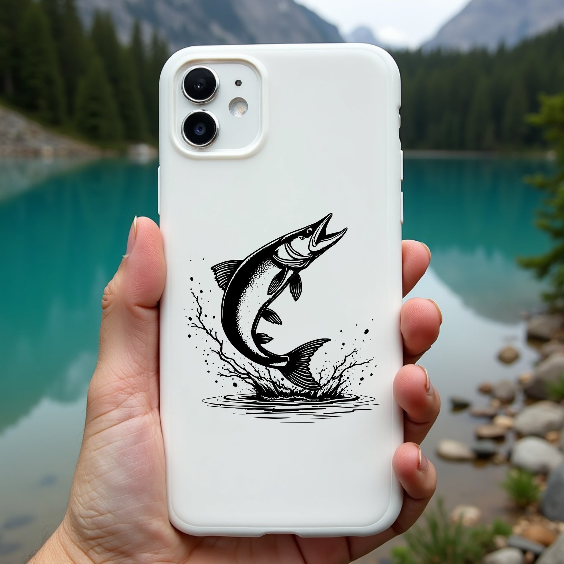 Phone case with muskie fish design held in front of a scenic lake and mountains
