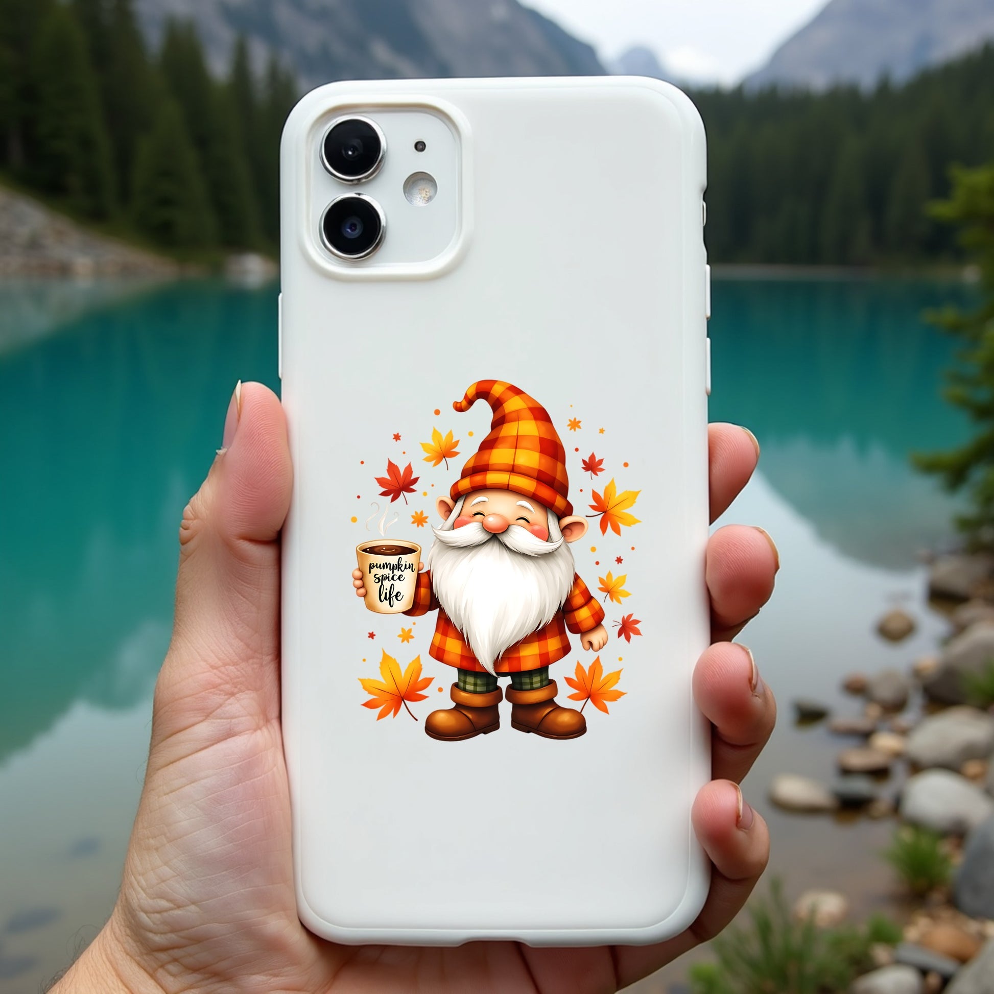 Phone case with a gnome design held by a hand, with a scenic background of a lake and mountains.