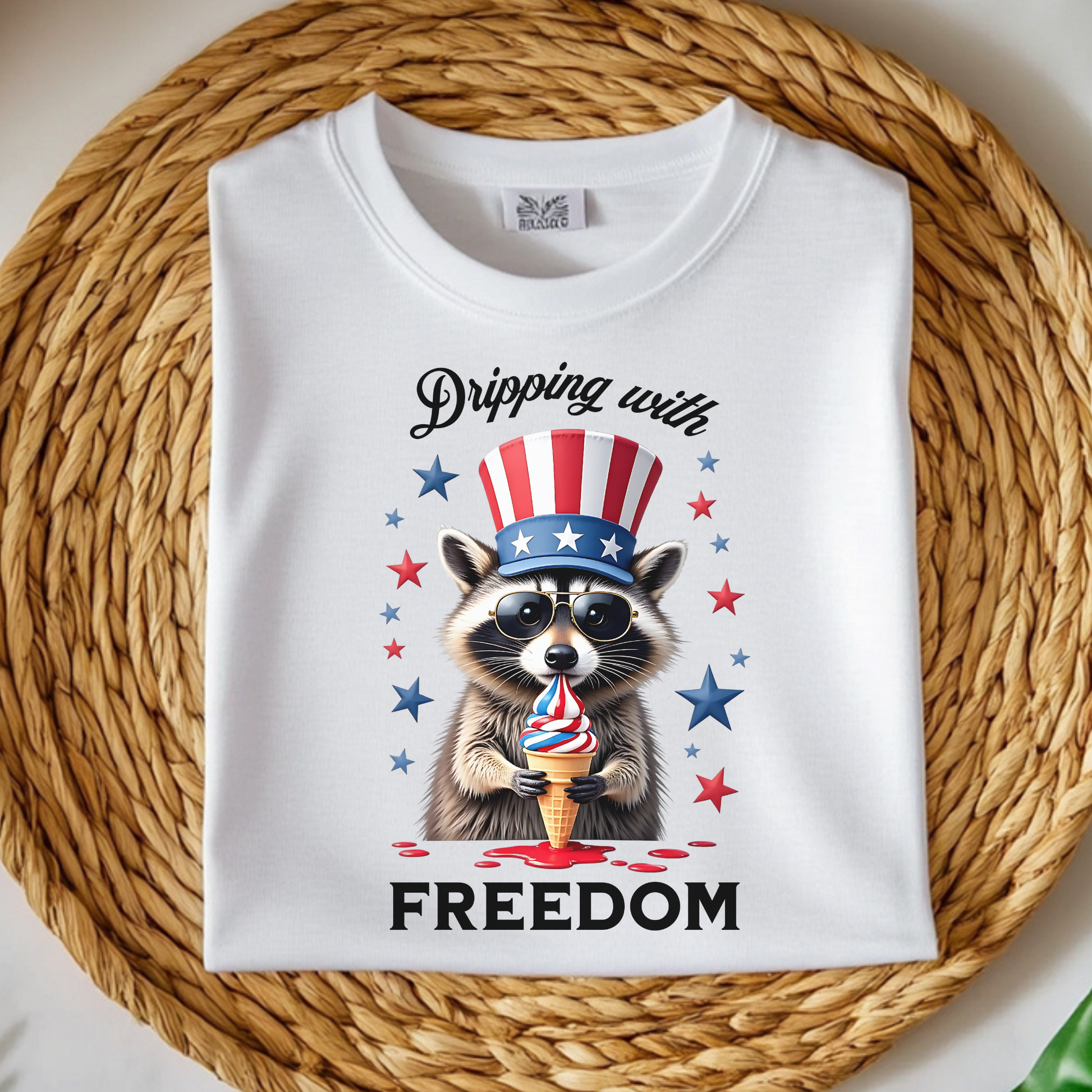 Dripping With Freedom Patriotic July 4th Raccoon design on a folded t-shirt