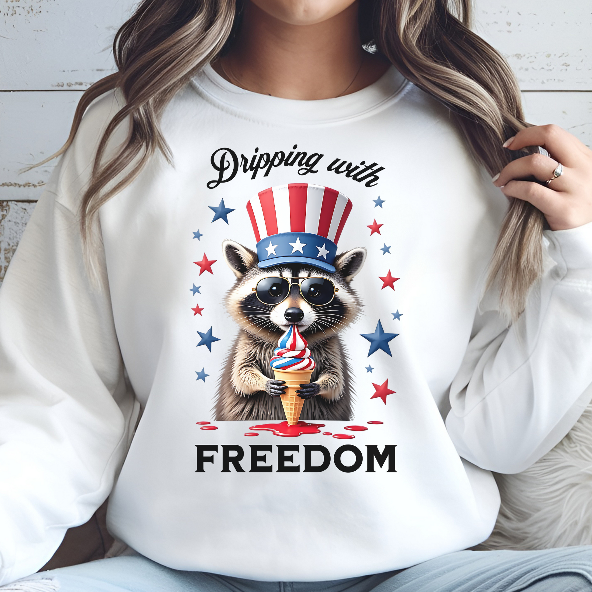 Dripping With Freedom Patriotic July 4th Raccoon design on a woman's white sweatshirt