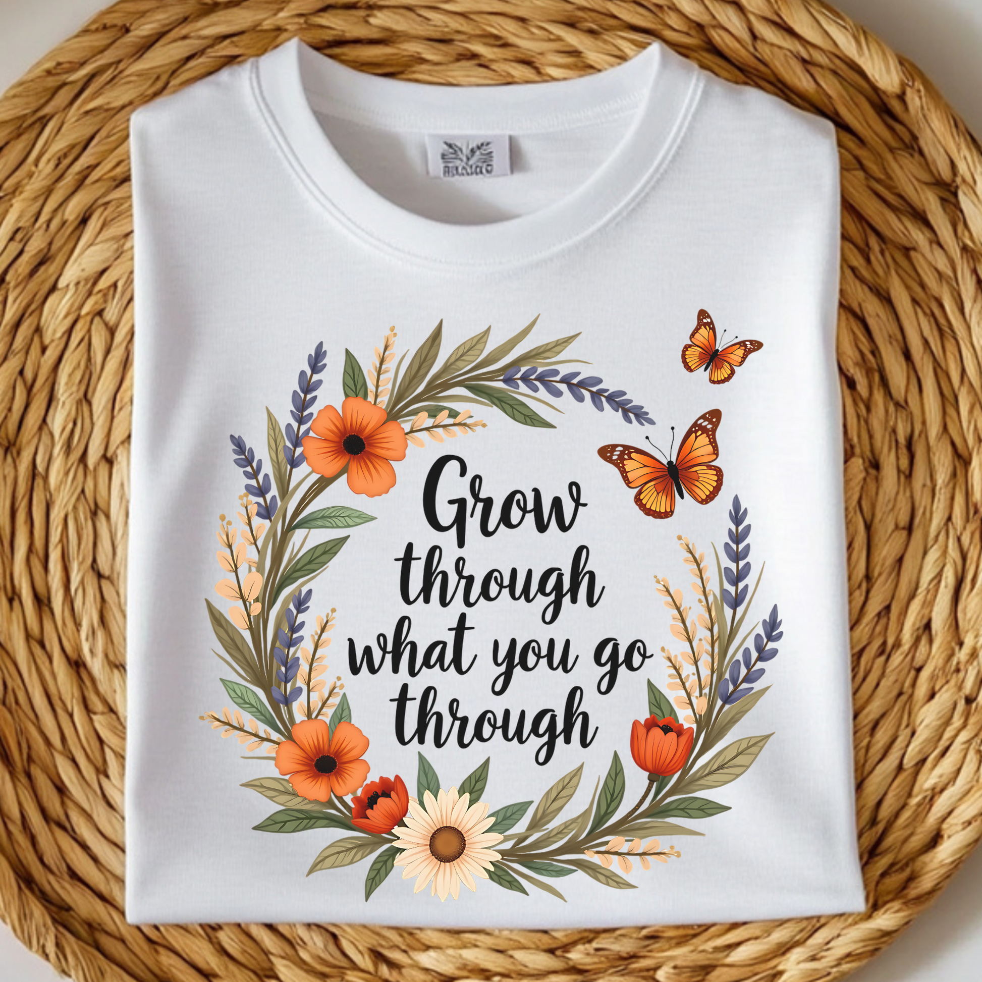 Grow Through What You Go Through PNG floral design with butterflies on a folded white t-shirt