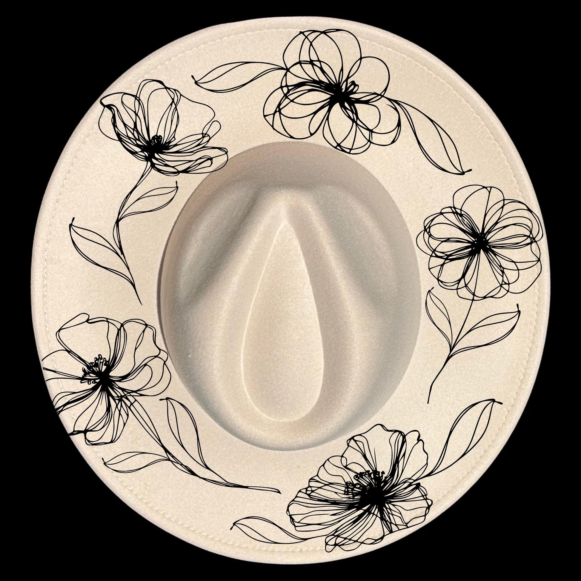 Wide brim hat with black floral design on a black background