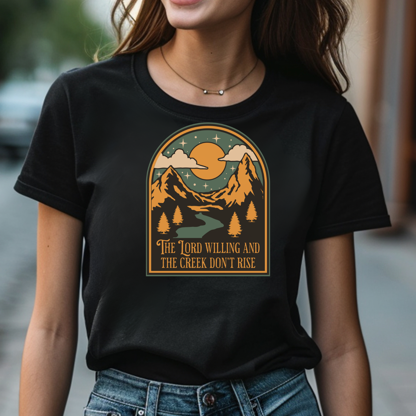The Lord Willing And The Creek Don't Rise digital design on a woman's black t-shirt