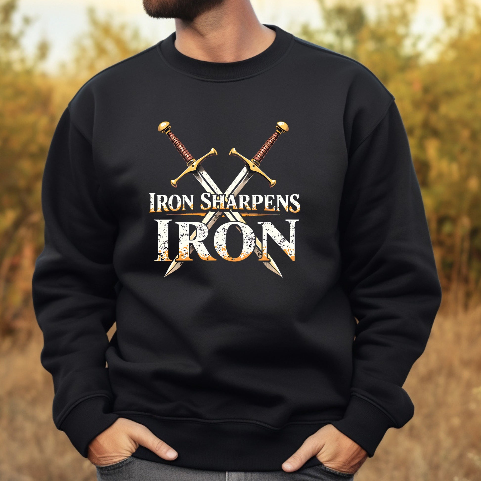 Black sweatshirt with 'Iron Sharpens Iron' text and crossed swords design, worn by a man outdoors.