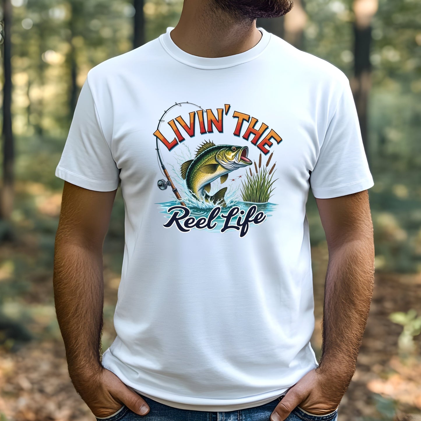Man wearing a white t-shirt with a fishing graphic and text 'Livin' The Reel Life' in a forest setting.