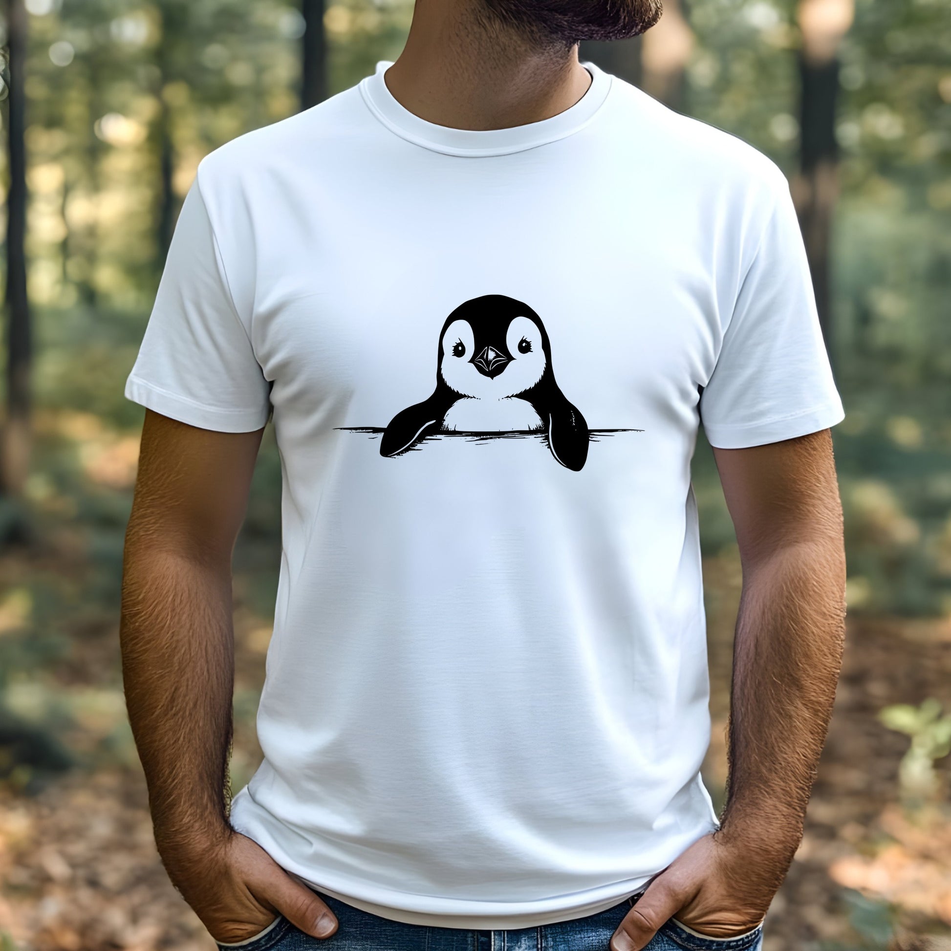 Person wearing a white t-shirt with a penguin design outdoors.