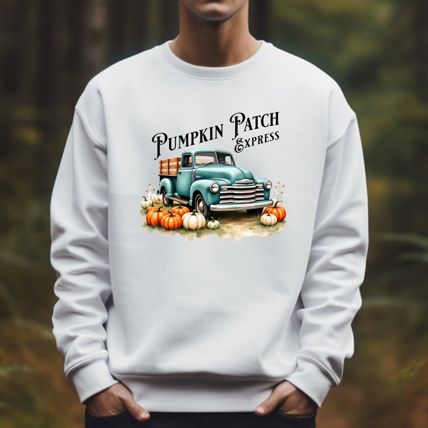 White sweatshirt with 'Pumpkin Patch Express' graphic featuring a vintage truck and pumpkins on a blurred natural background.