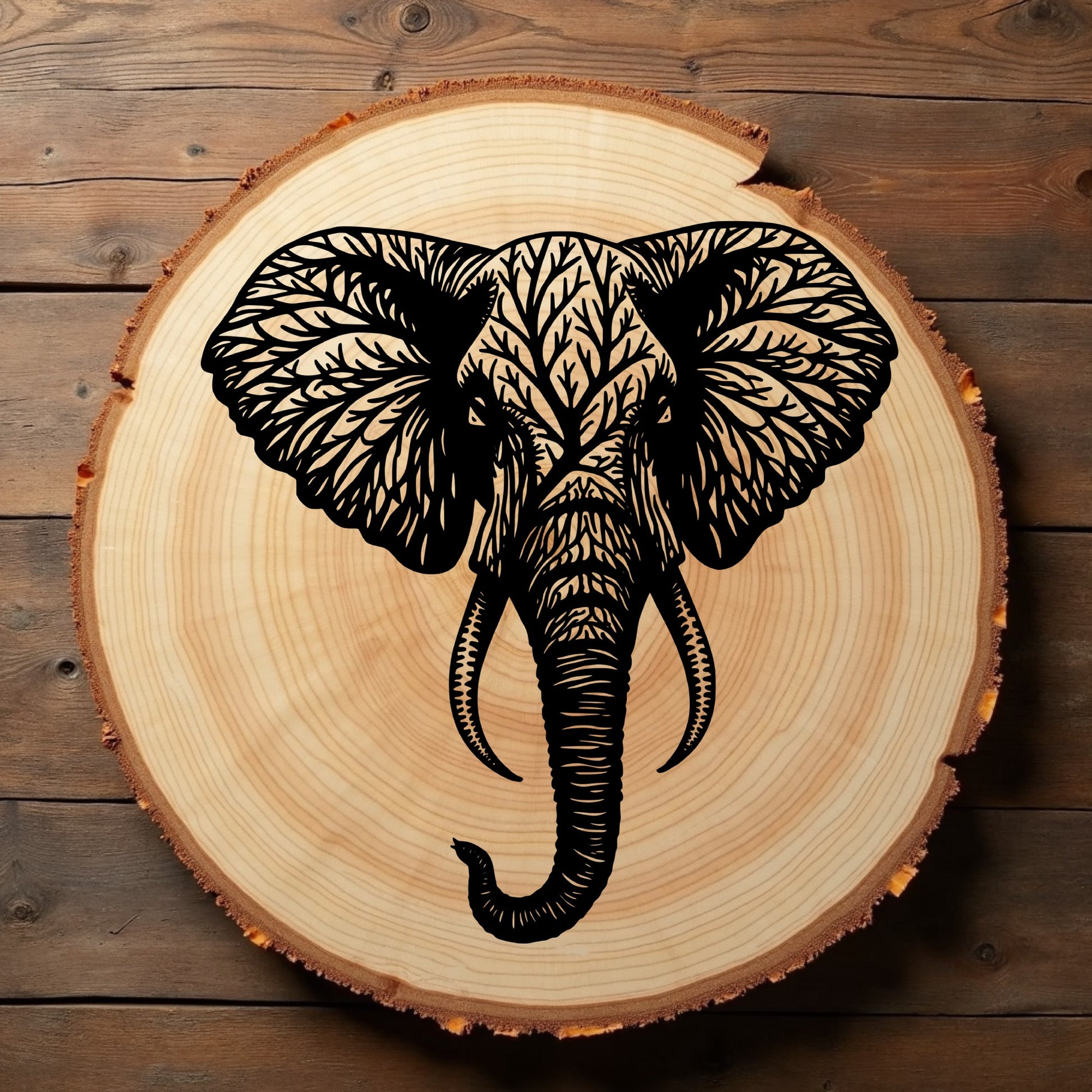 Wooden slice with a black elephant tree engraving sitting on a wooden background