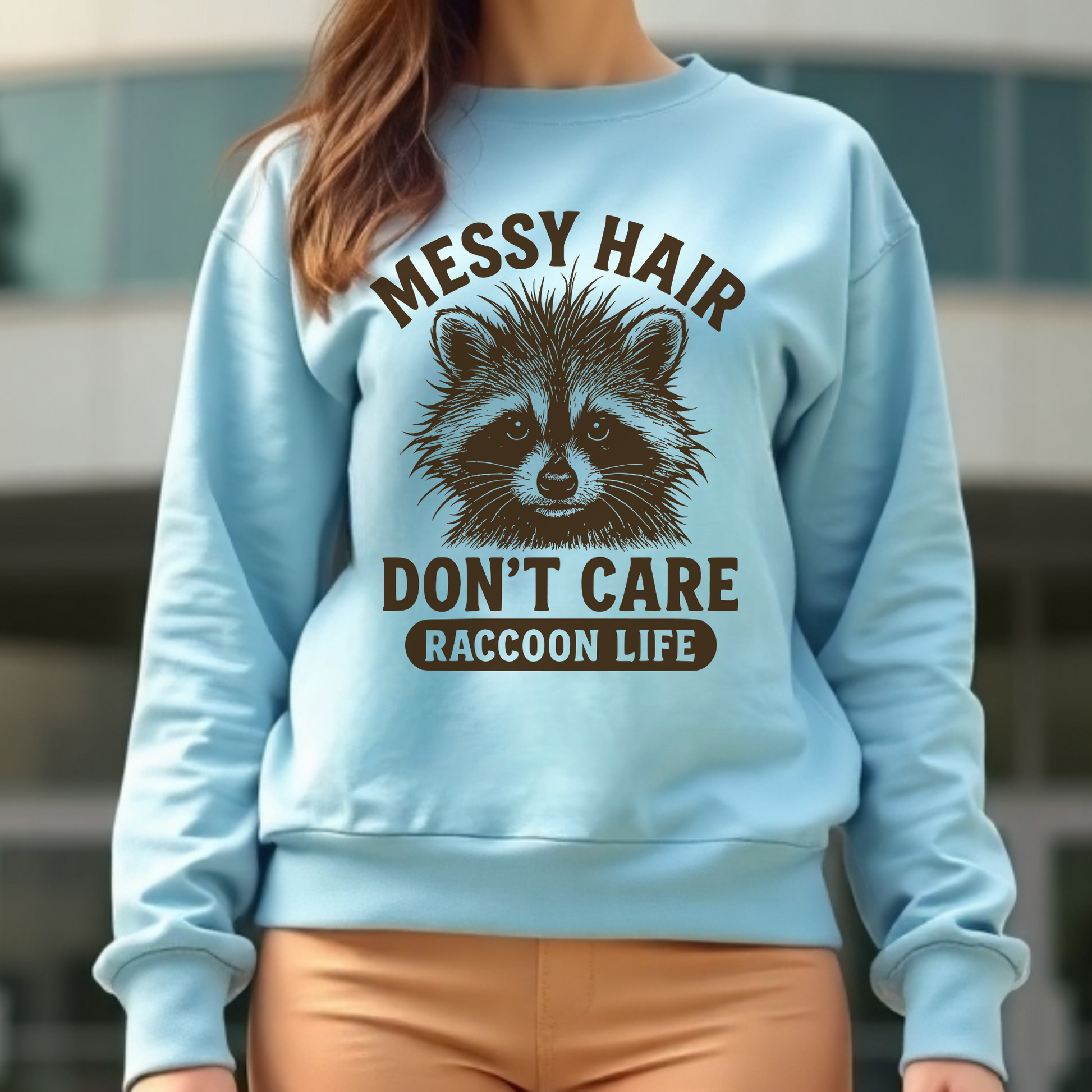Messy Hair Don't Care Raccoon Life digital design on a woman's blue sweatshirt