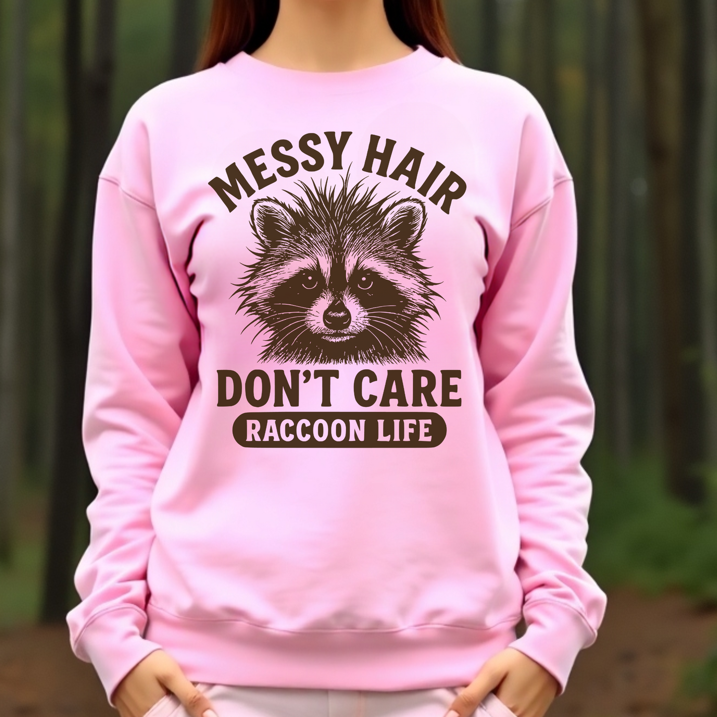 Messy Hair Don't Care Raccoon Life digital design on a woman's pink sweatshirt