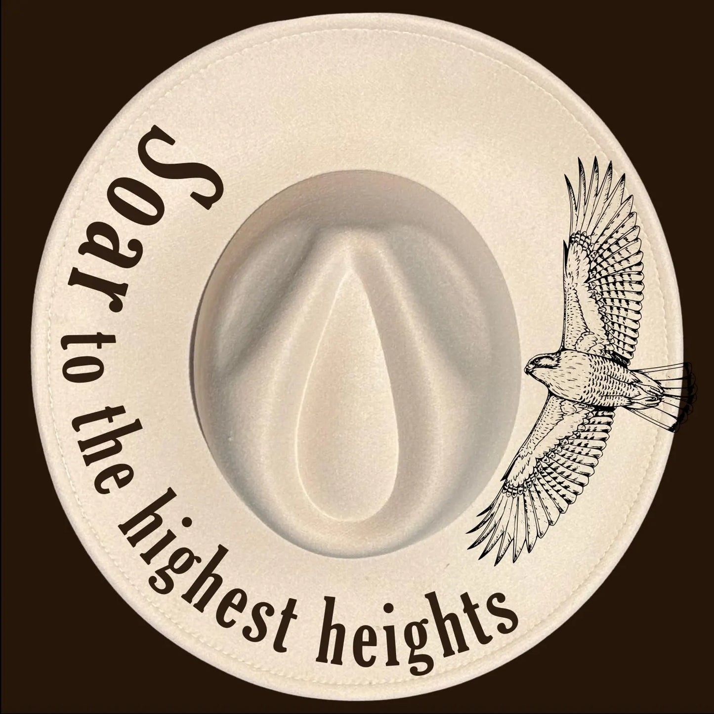 A wide brim burned hat with a bird illustration and motivational text on a dark background