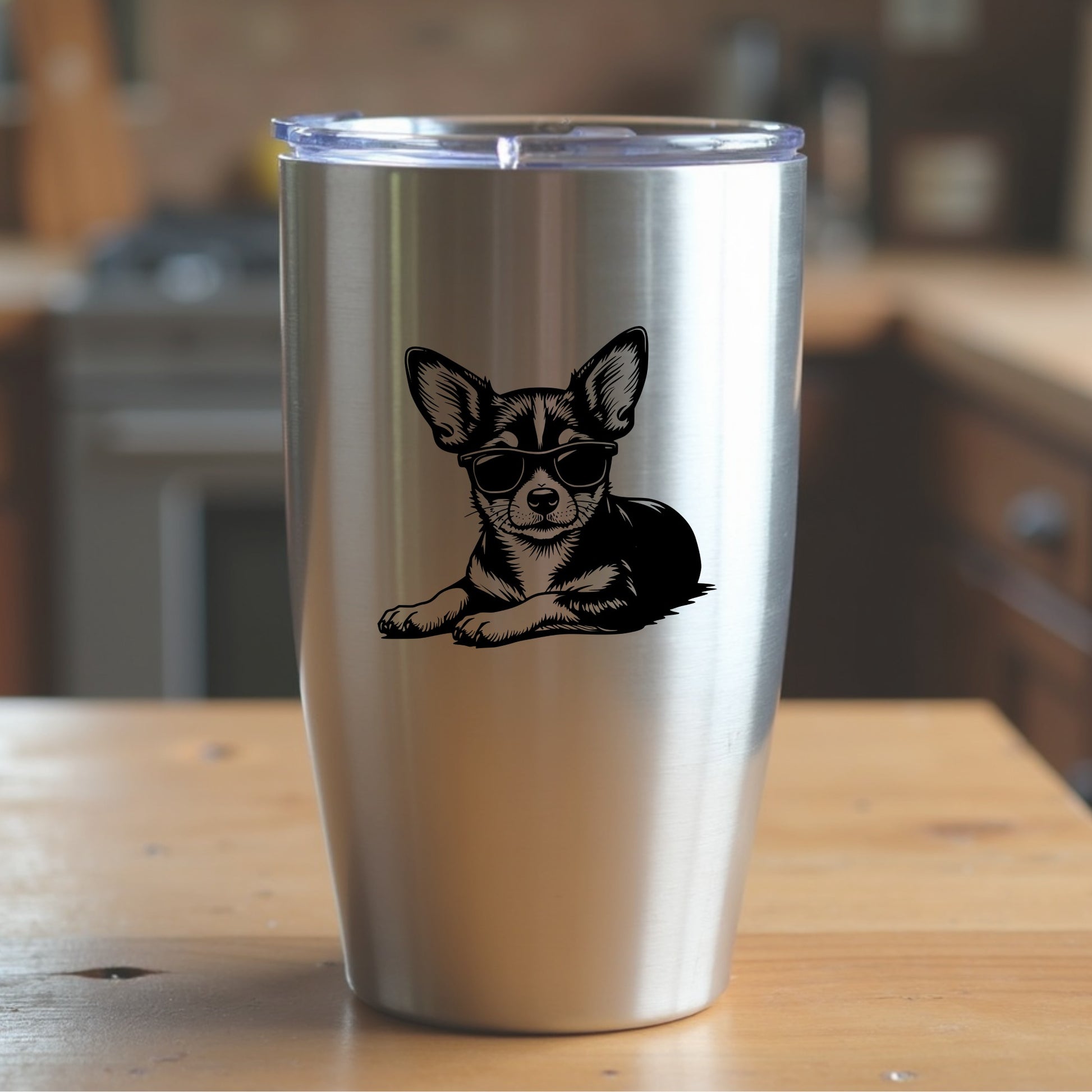 Stainless steel tumbler with a chihuahua illustration wearing sunglasses on a wooden surface.