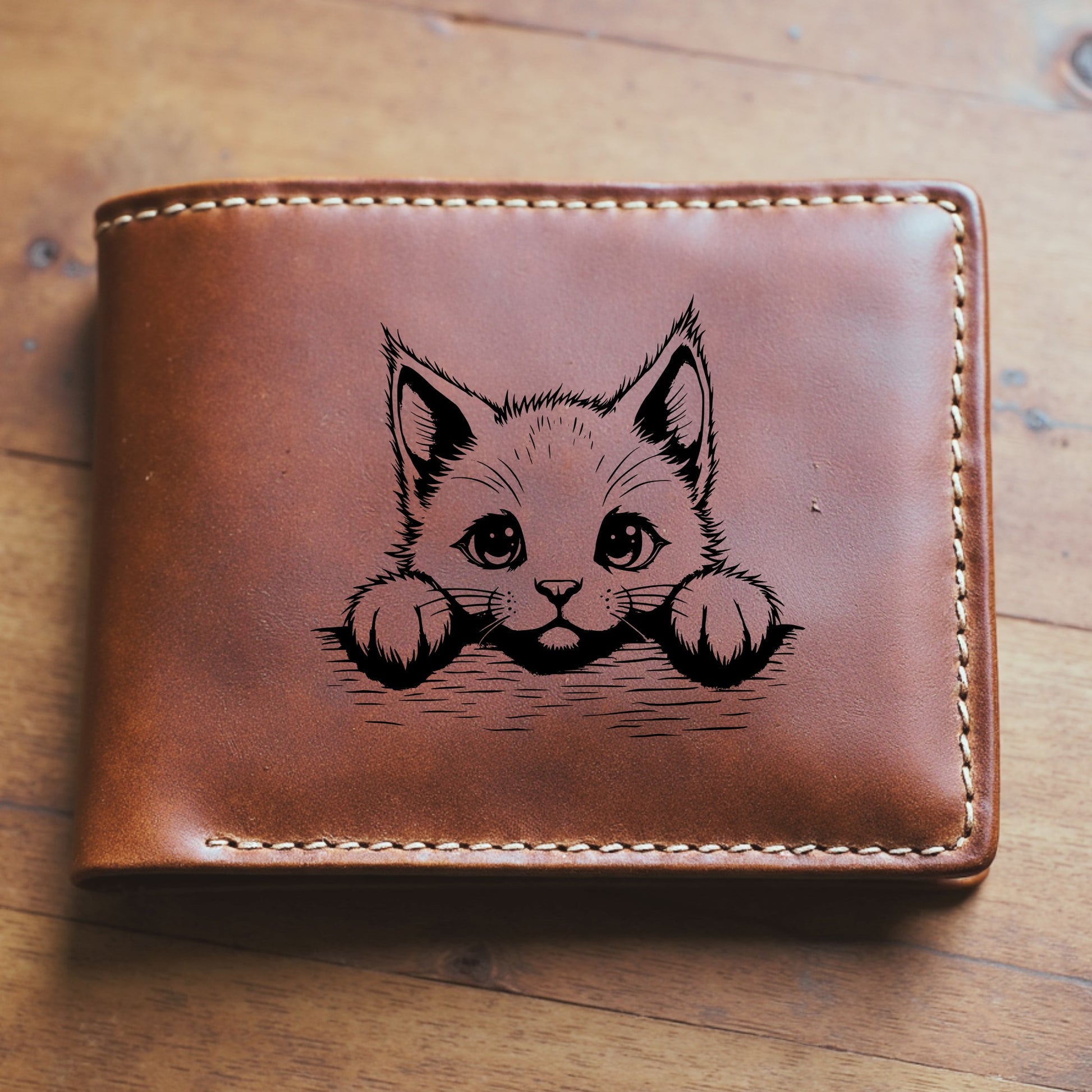 Brown leather wallet with a cat illustration on a wooden surface