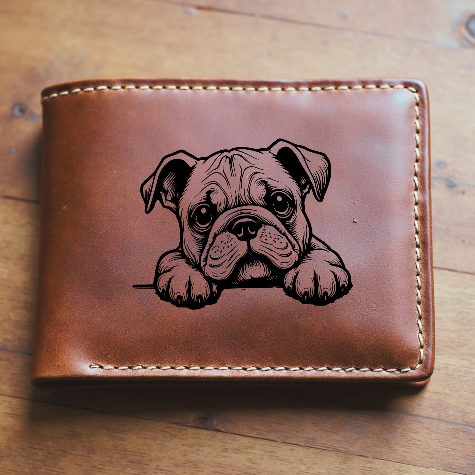 Brown leather wallet with a engraved bulldog design sitting on a wooden surface