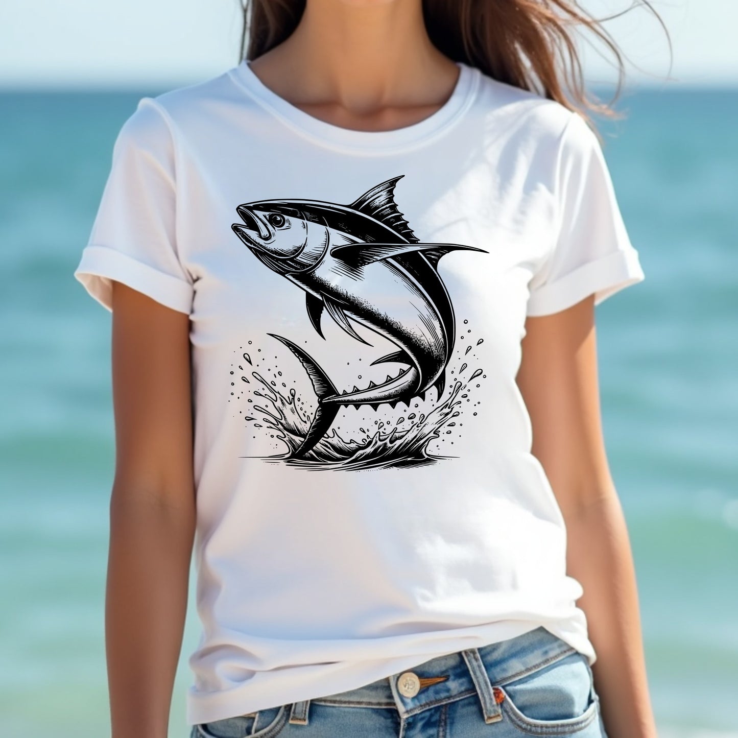 Woman wearing a white t-shirt with a black tuna fish design against a blurred beach background