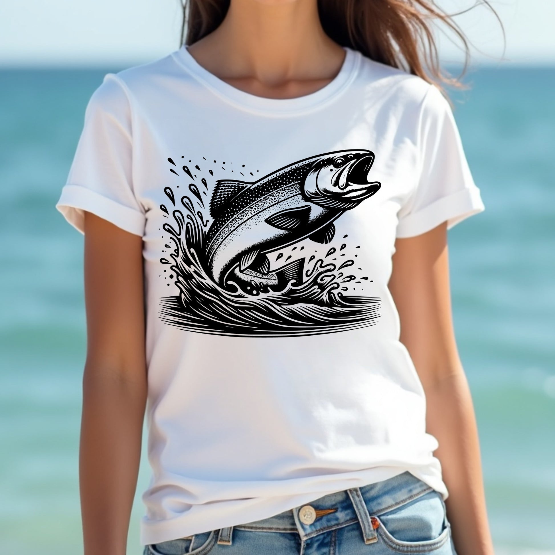 Woman wearing a white t-shirt with a black trout fish design against a blurred beach background