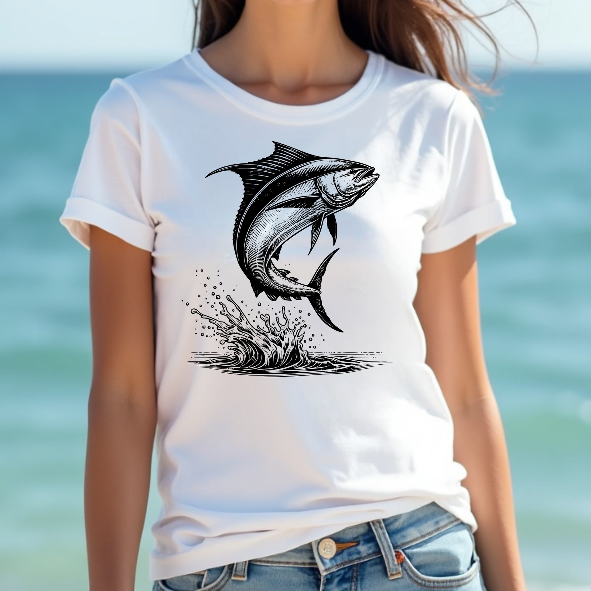 Woman wearing a white t-shirt with a black mahi-mahi fish graphic design against a blurred beach background
