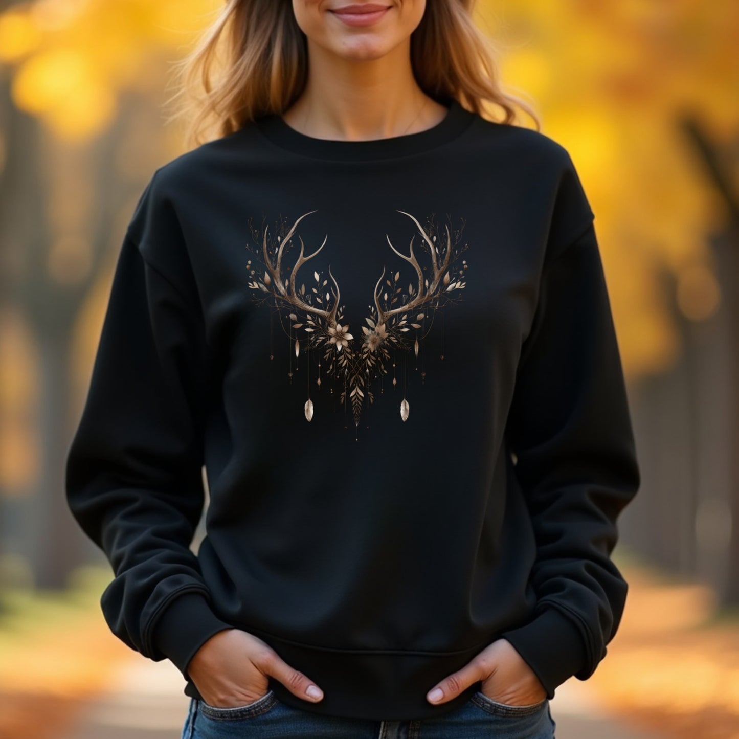 Woman wearing a black sweatshirt with a deer antler design in an autumn setting