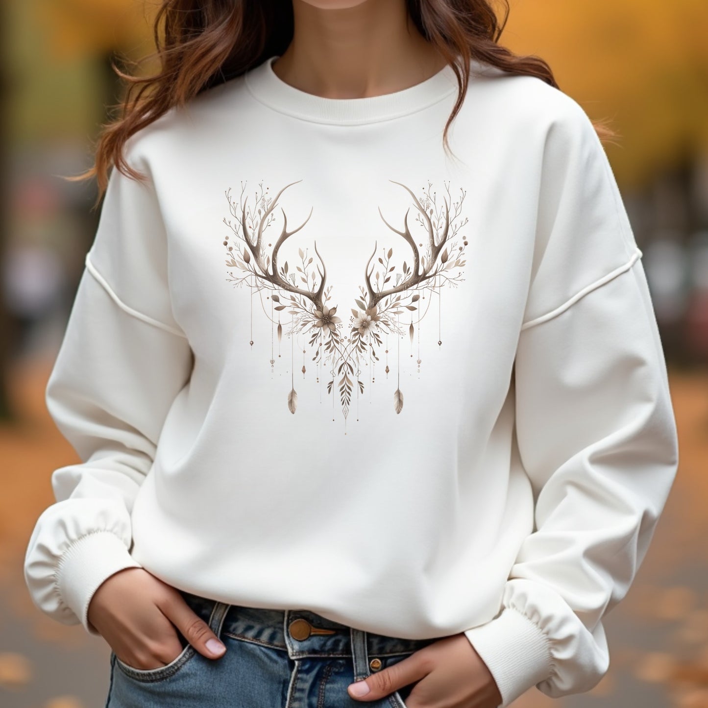 White sweatshirt with deer antler design worn by a woman outdoors.