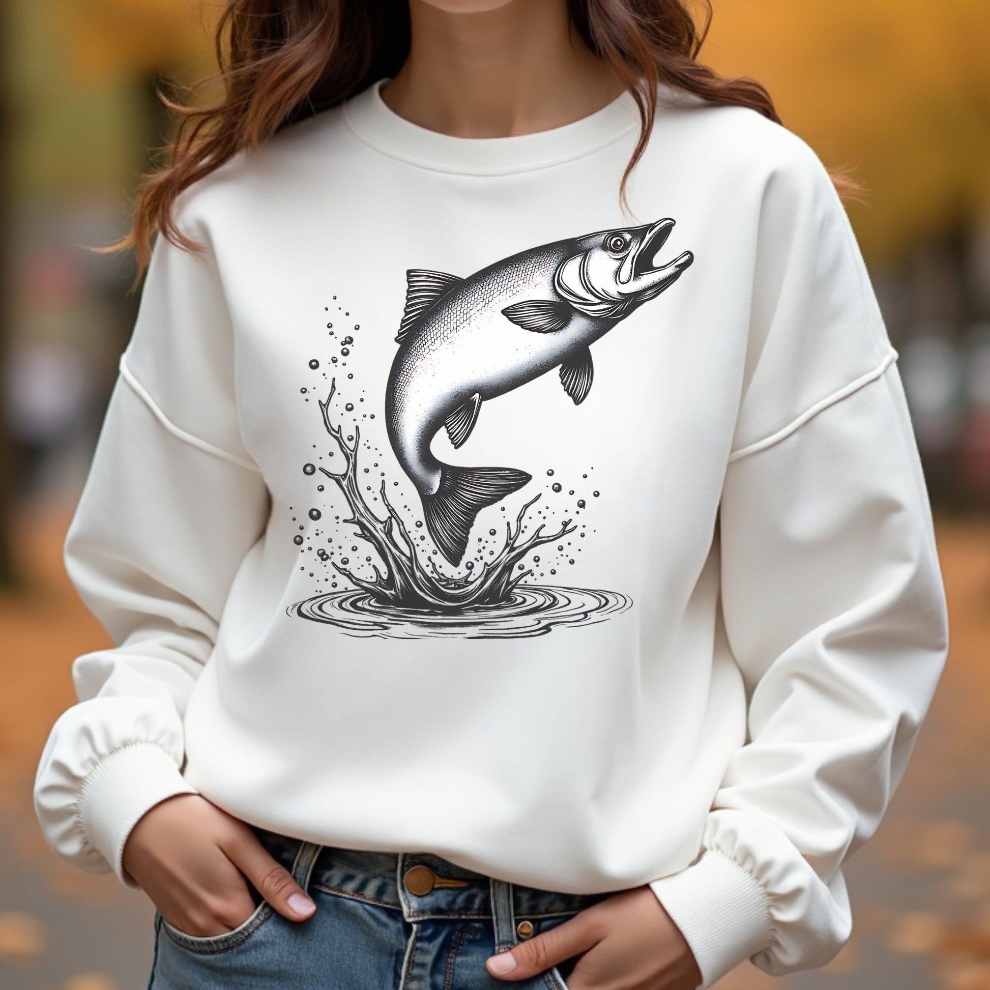 Woman wearing a white sweatshirt with a fish graphic design outdoors.