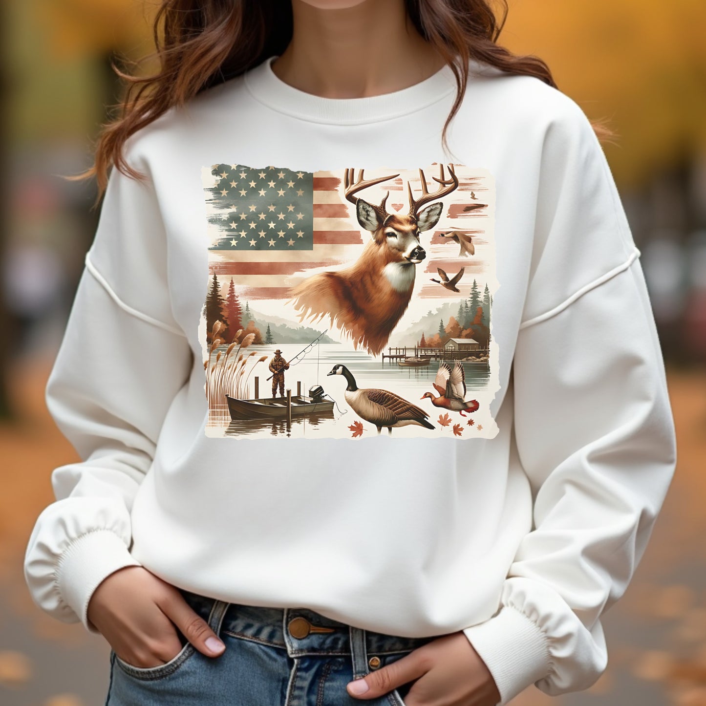 White sweatshirt with a nature-themed design featuring a deer, American flag, and outdoor scene.