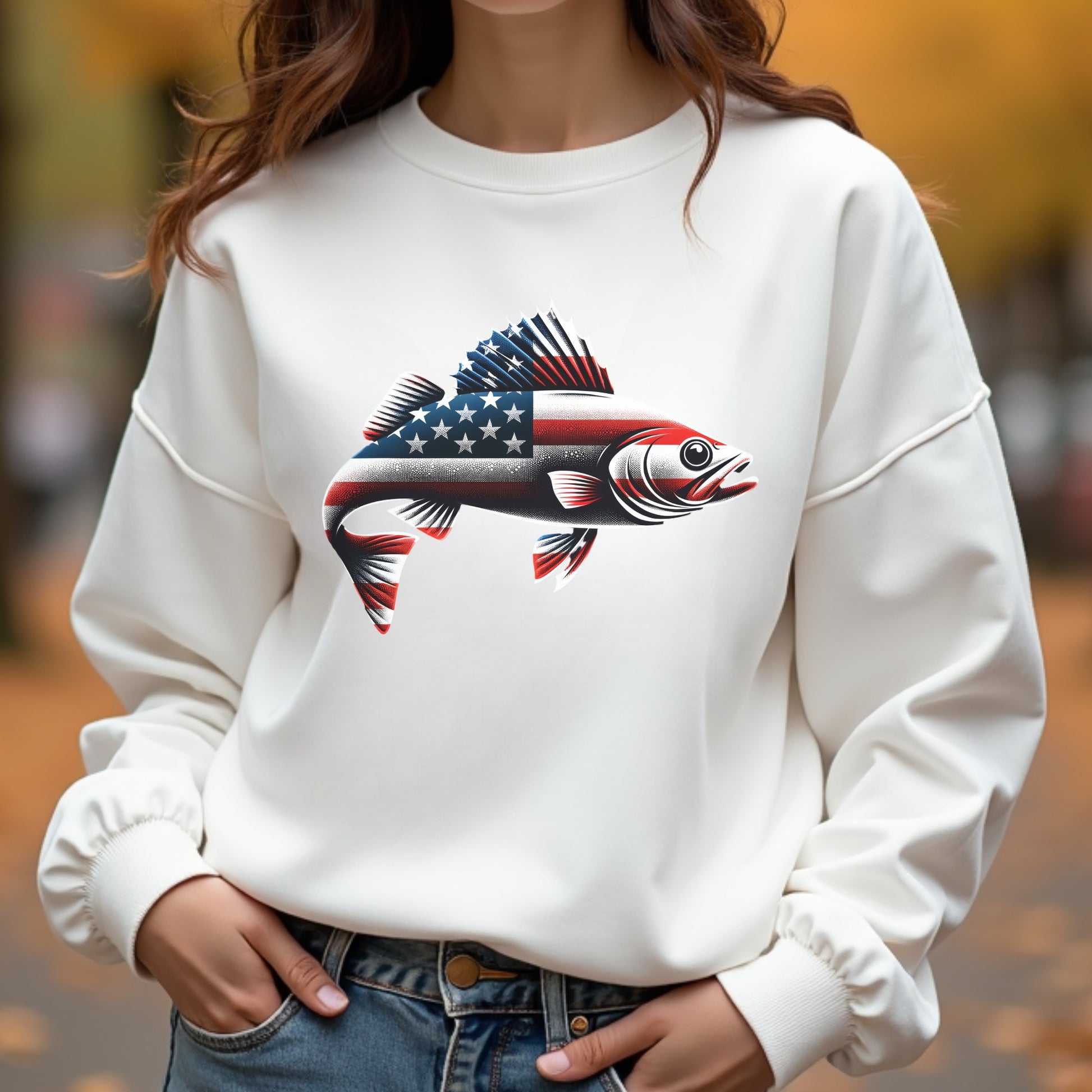 White sweatshirt with a walleye fish design featuring the American flag, worn outdoors.