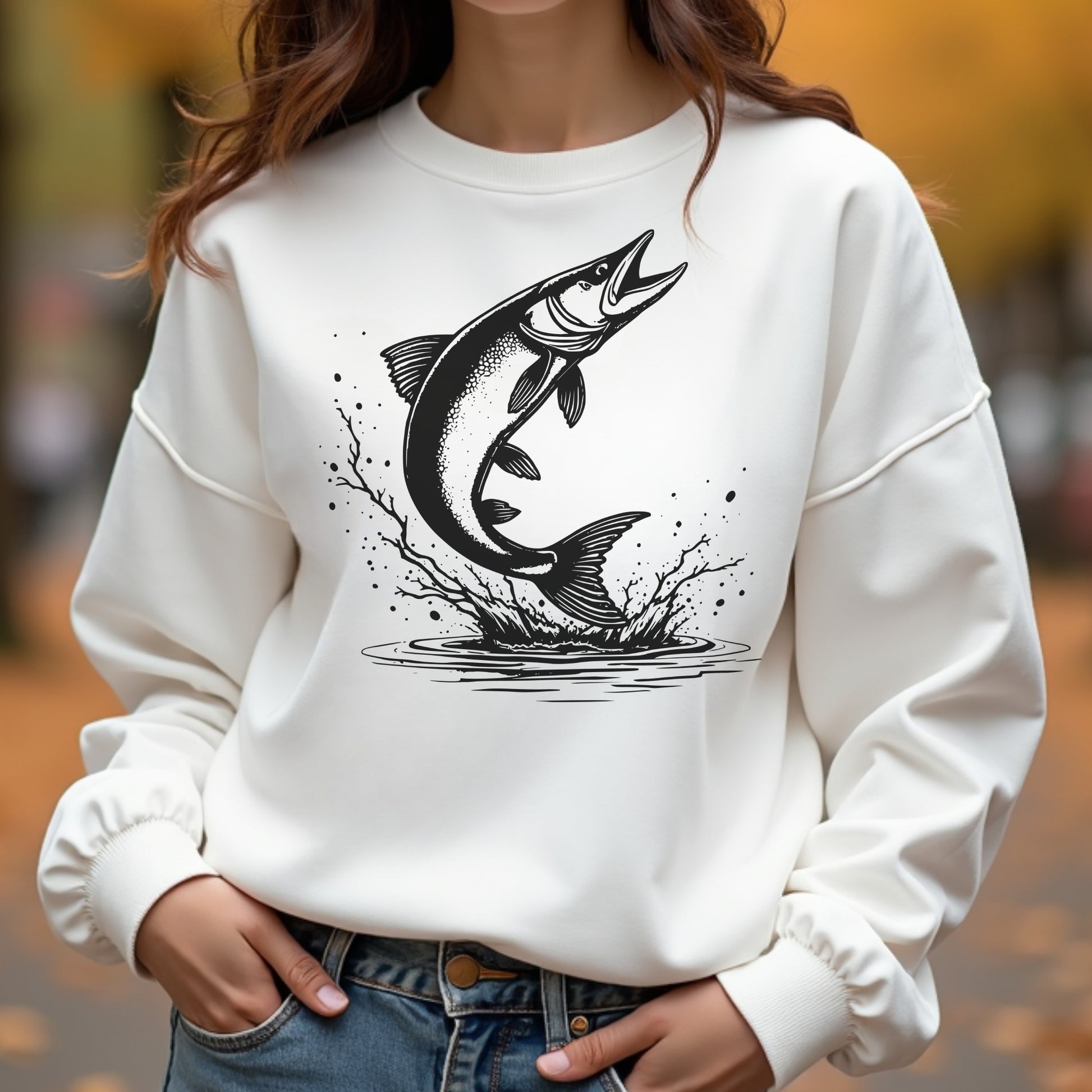 Woman wearing a white sweatshirt with a black fish graphic design outdoors.