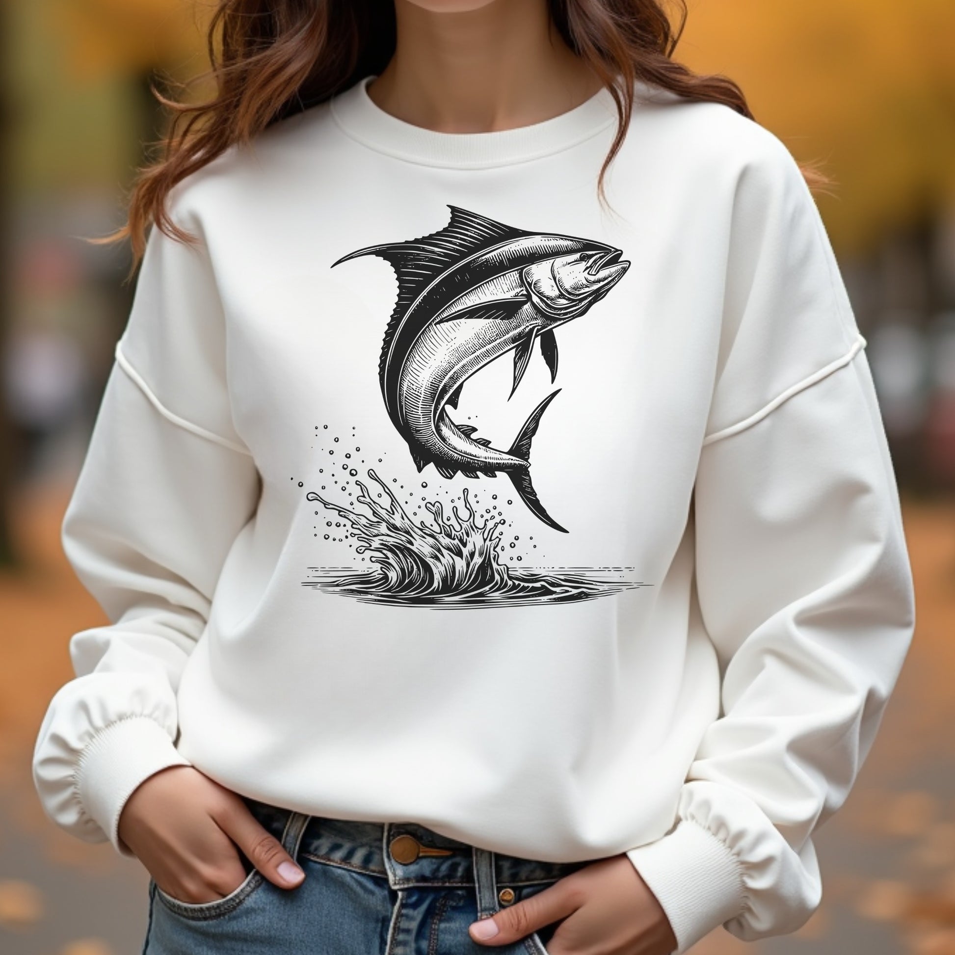 White sweatshirt with a mahi-mahi fish graphic worn by a woman outdoors.