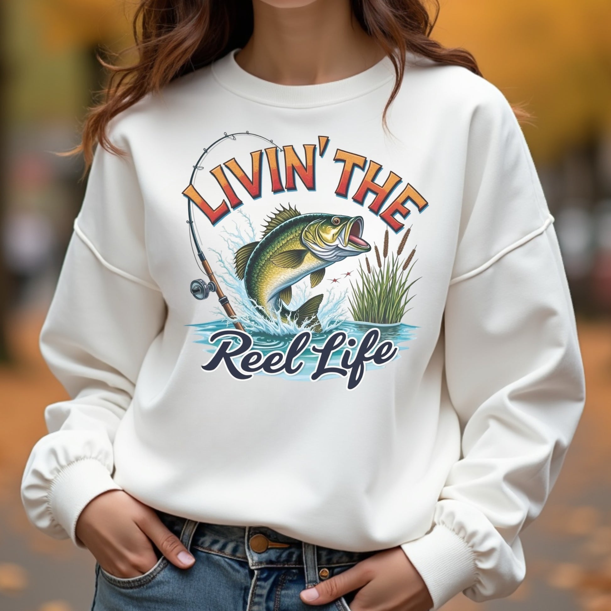 Woman wearing a white sweatshirt with a fishing-themed design and text.