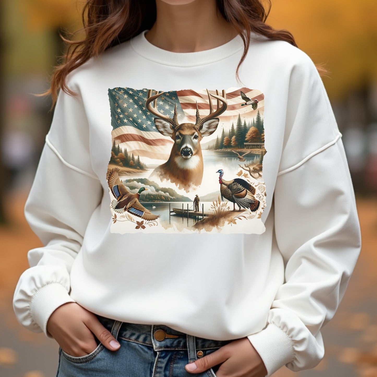White sweatshirt with nature-themed design featuring a deer, American flag, and landscape.