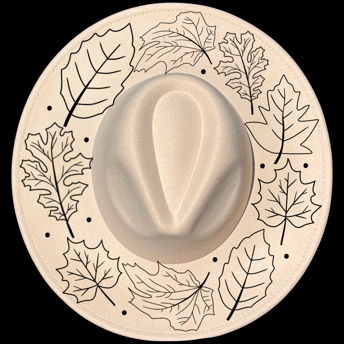 A beige-colored hat with a wide brim featuring a floral pattern of fall leaves and dots around the edge.
