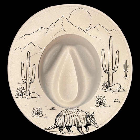 A wide brim hat with desert scene including cacti, mountains, and an armadillo.
