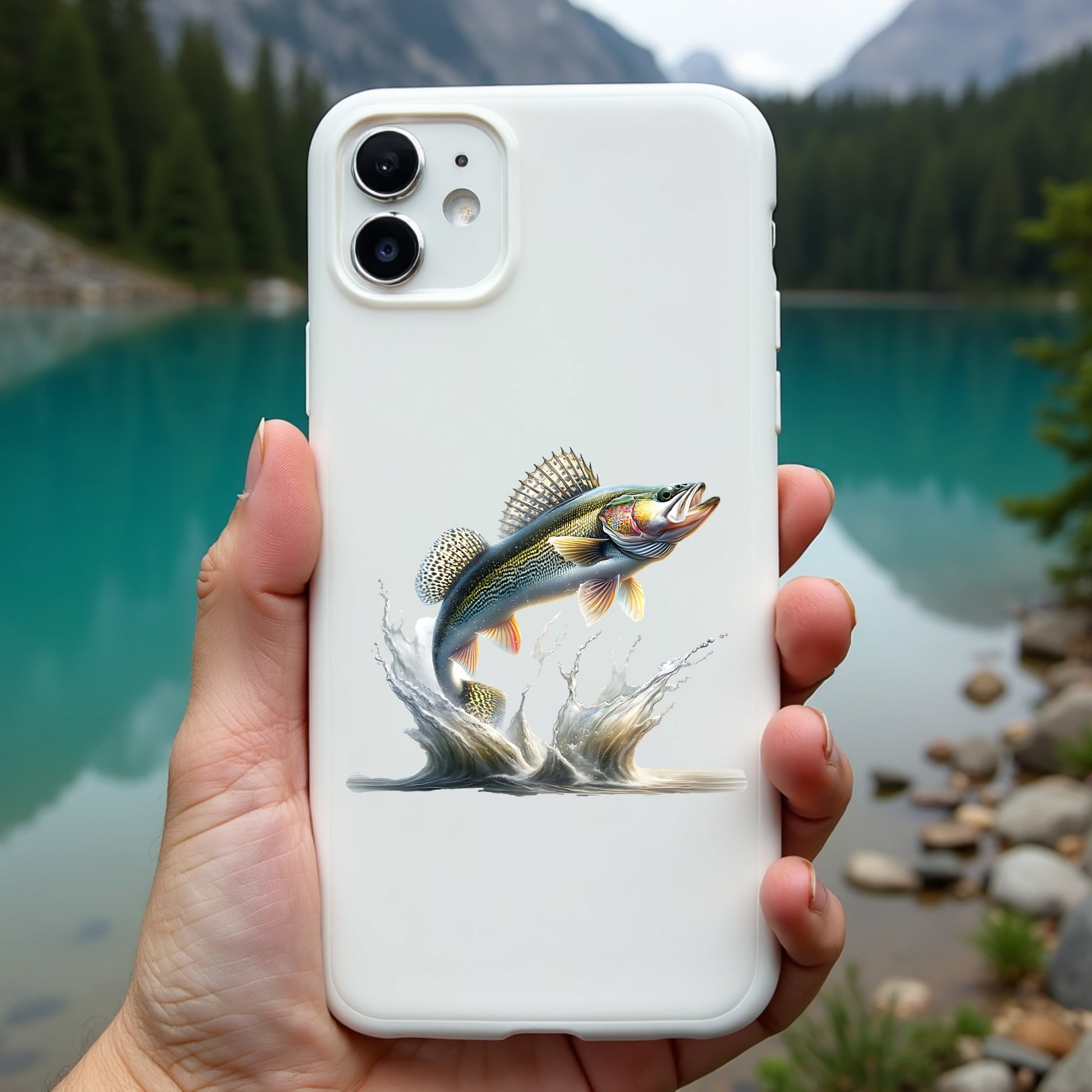 Phone case with a walleye fish design held in front of a scenic lake and mountains