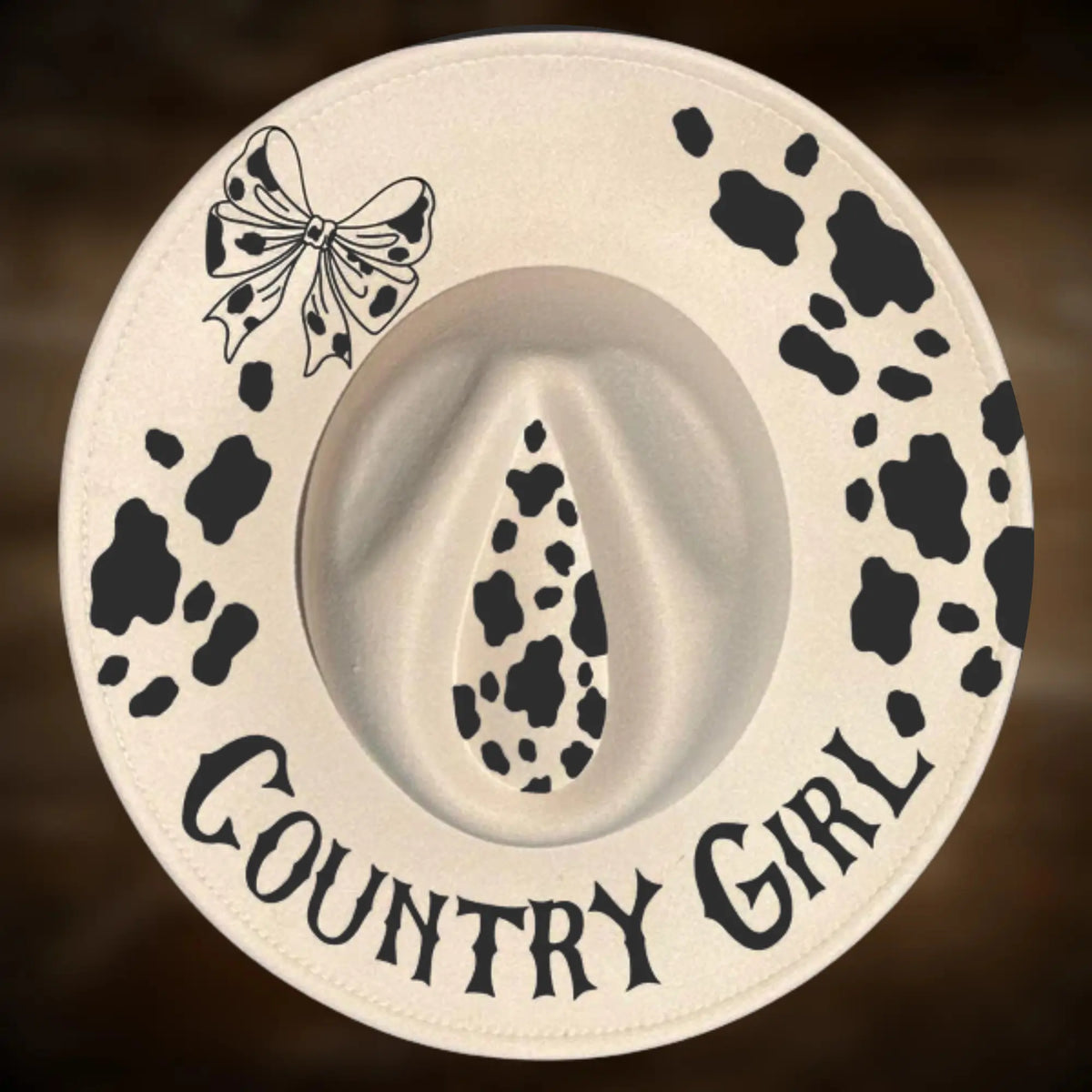 Cowboy hat with cow print and 'Country Girl' text on a brown background