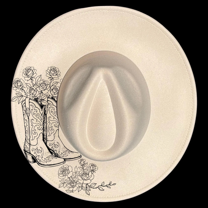 Cowboy hat with black boot and floral design on a white background